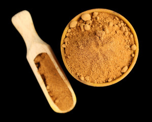 Paprika in wooden bowl, isolated on black