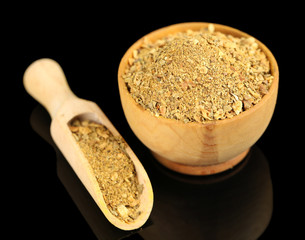 Curry in wooden bowl, isolated on black
