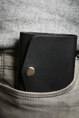 Man hand made leather wallet in pocket, close up