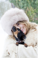 pretty lady cuddle her little dog in winter time
