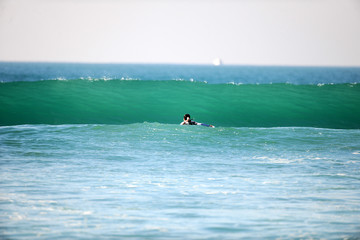 Surfer auf dem Meer paddelt eine Welle an