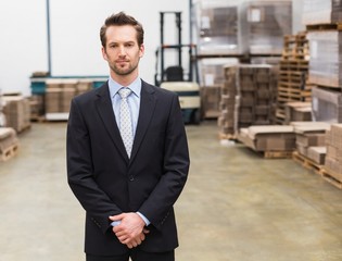 Warehouse manager standing hands together