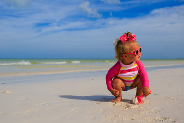 little girl playing on summer beach