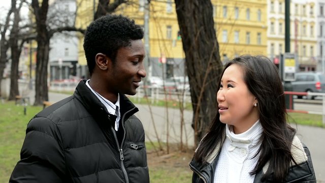 Happy couple talk (conversation) - black man and asian woman