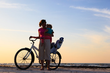 Silhouette of mother and baby biking