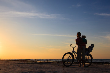 Fototapeta na wymiar Silhouette of mother and baby biking