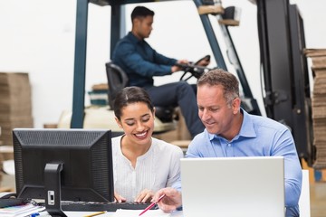 Warehouse managers working with laptop at desk