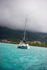 Fototapeta premium Recreational Yacht in fog at the coast of Seychelles