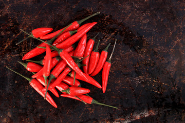 Bunch of red thai chili peppers on brown background