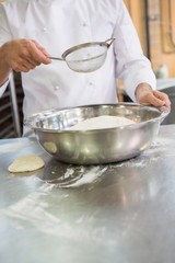 Baker working with sieve and bowl