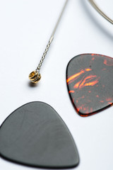 Electric guitar string with two mediators on white surface