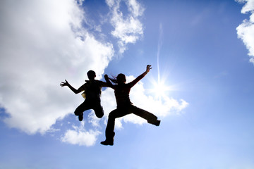 Fototapeta na wymiar silhouette of women and the boy jump to the sky