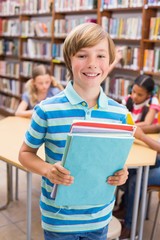 Cute pupil smiling at camera in library