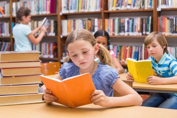 Cute pupils reading in library