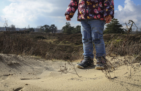 Little girl standing in dunes in forest