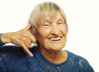 senior woman is making a call me gesture
