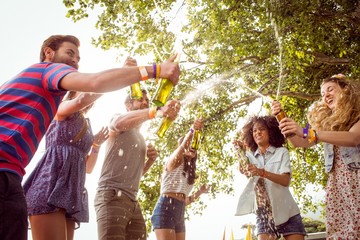 Fototapeta premium Happy hipsters spraying beer bottles