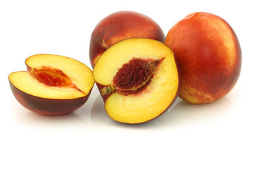 fresh nectarines and a cut one on a white background