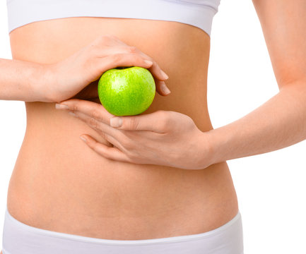 Slim woman in white underwear with green apple at her hands over