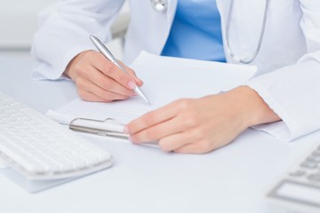 Female doctor writing prescriptions at table