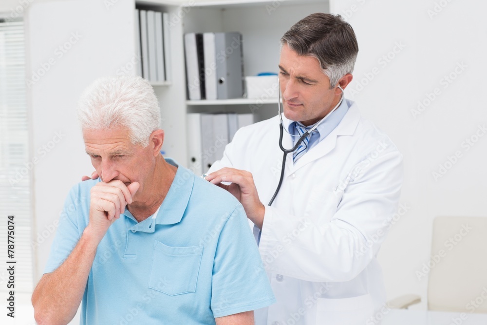 Wall mural doctor examining coughing senior patient