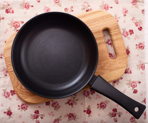 Empty frying pan on wooden background.