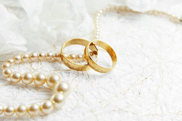 Two golden wedding rings with seamless flower decorations