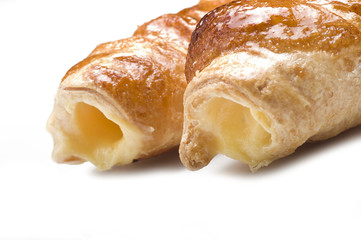 Italian cannoli filled with egg custard on white background