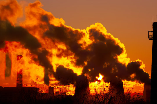 power plant smokestacks at sunset