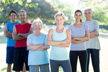 Happy athletic group smiling at camera with hands crossed