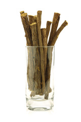 licorice root (sticks) in a glass on white background