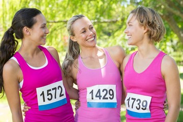 Smiling women running for breast cancer awareness