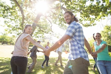 Fototapeta premium Happy friends in the park holding hands
