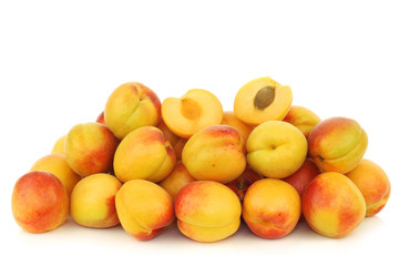 Fototapeta na wymiar fresh colorful apricots and a cut one on a white background