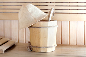 Traditional wooden sauna for relaxation with bucket of water