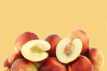 fresh nectarines and a cut one on a orange background