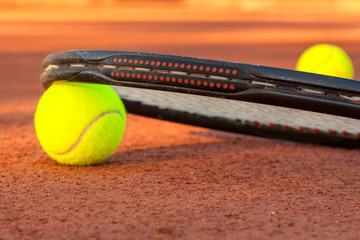 Tennis ball and racquet on a tennis clay court