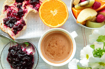 Healthy breakfast with jam, sliced fruits and cup of coffee