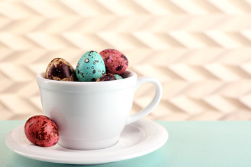 Bird colorful eggs in mug on light background