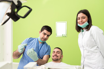 Dentist Explaining Artificial Teeth To Patient In Clinic