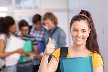 Female student gesturing thumbs up in college
