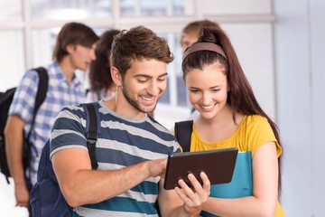 Smiling students using digital tablet