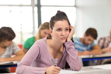 Female student writing notes in classroom