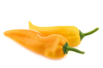 two fresh yellow sweet peppers (capsicum) on a white background