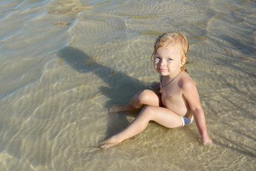 a child sunbathes on a beach