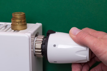 Radiator thermostat, coins and hand - dark green