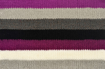 Purple with black and white colors stripes on fabric background.