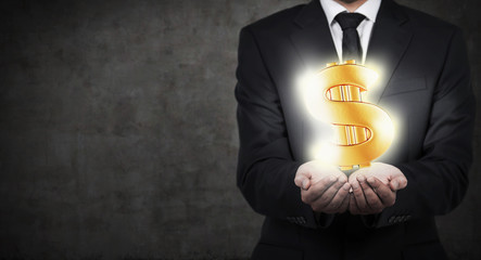 businessman holding gold dollar