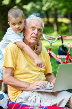 grandfather and child using laptop