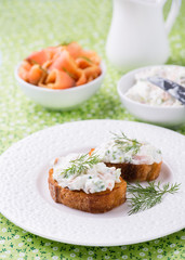 Canape with soft cheese spread on white plate